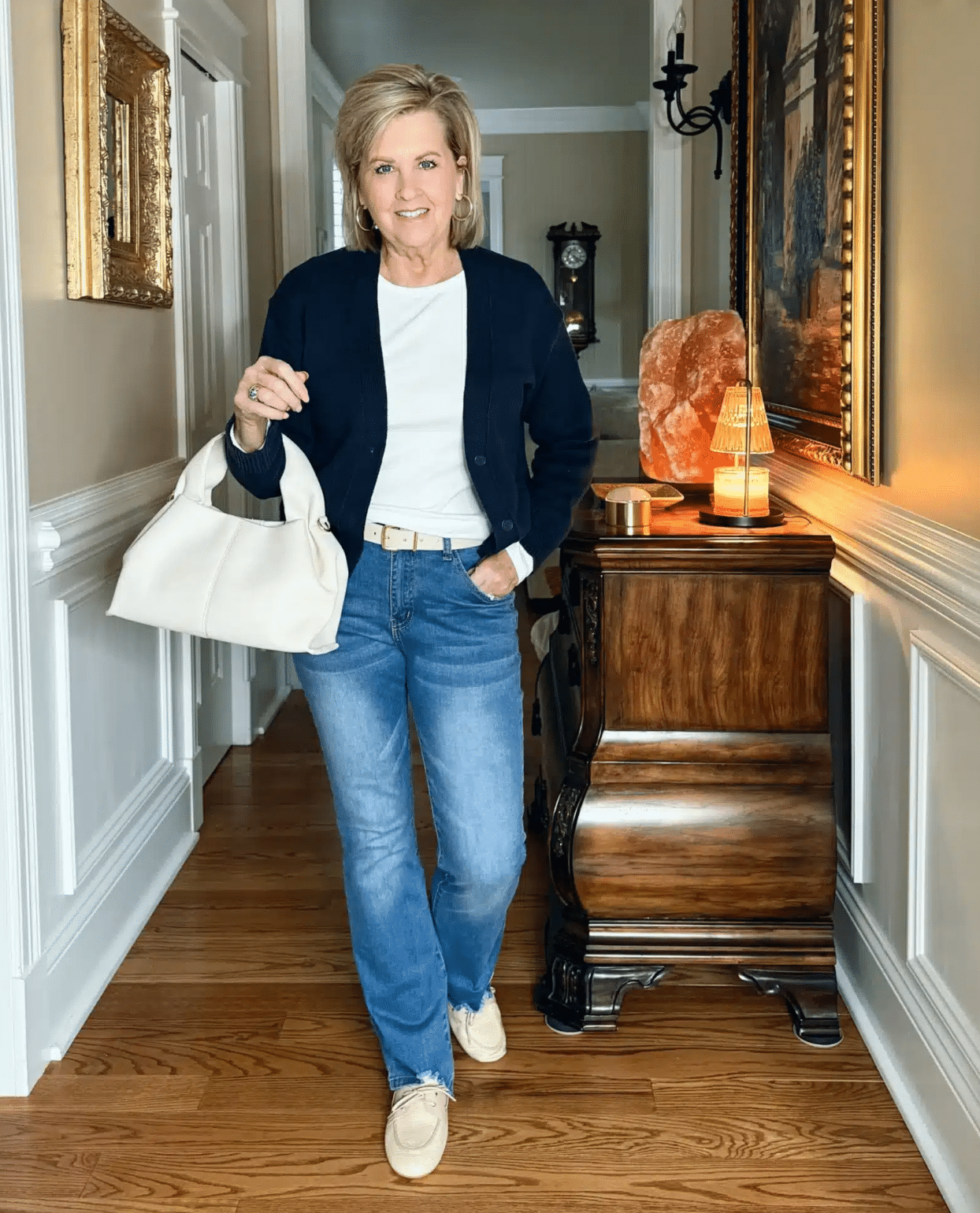 Tania Stephens in a white ribbed long sleeve tee, cropped cardigan, and flared jeans